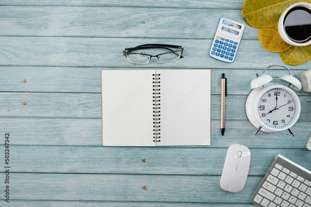 Poster Office desk with keyboard computer, Pen, eyeglass, notebook, Cup of coffee on wood background, Top view with copy space, Mock up.