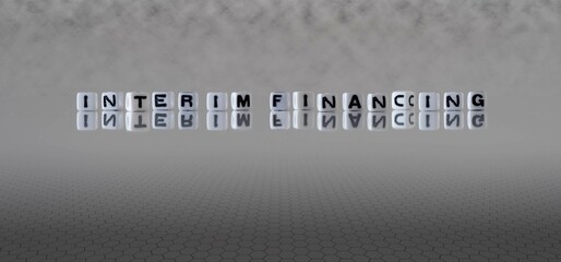 interim financing word or concept represented by black and white letter cubes on a grey horizon...