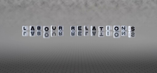 labour relations word or concept represented by black and white letter cubes on a grey horizon background stretching to infinity