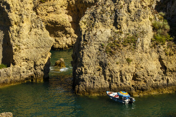 Panoramic view with Cliff, rocks and tourist boat on sea at Ponta da Piedade near Lagos, Algarve, Portugal