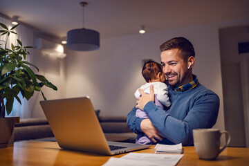 A happy businessman holding his daughter and having online meeting from home.