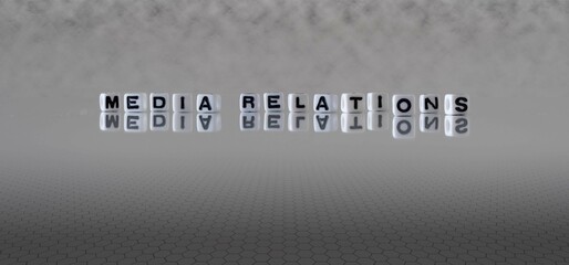 media relations word or concept represented by black and white letter cubes on a grey horizon background stretching to infinity
