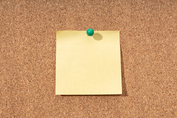 Cork board with blank yellow note for adding text. Mock up