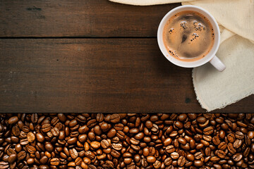 Cup of coffee with coffee beans on table