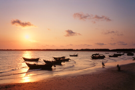 Guangdong maoming romantic coast with some boats under sunset