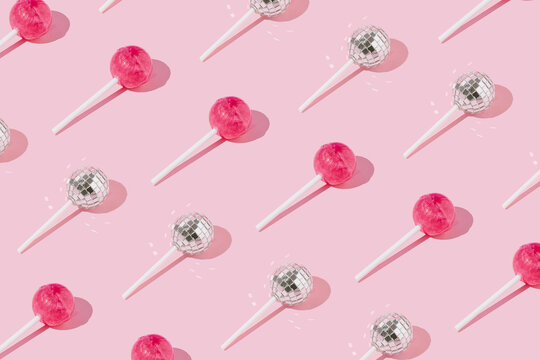 Lollipop candy and disco ball on lollipop stick pattern on pink background. Top view. Minimal concept.