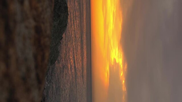SUNSET OR SUNRISE OVER THE SEOR OCEAN. Dramatic sky in clouds against backdrop of sunset or debacle. Rocky shore.