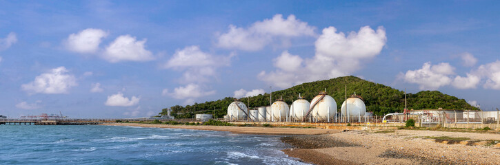 Panorama of petroleum crude oil silo container storage site located next to the sea shore with...