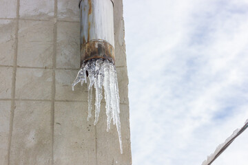 Frozen water in a drainpipe. Icicles in the rainwater pipe