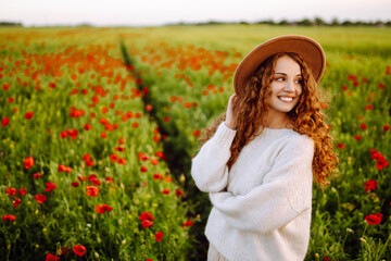 Beautiful woman in the blooming poppy field. Nature, vacation, relax and lifestyle. Summer landscape.