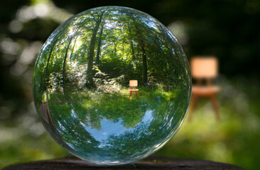 Focus on taking care of nature and the climate shown with nature encased in a crystal ball with a chair in nature