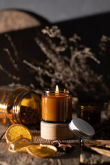 A set of different aroma candles in brown glass jars. Scented handmade candle. Soy candles are burning in a jar. Aromatherapy and relax in spa and home.