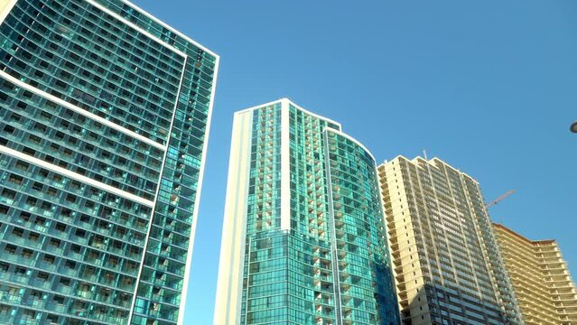 View from below of modern skyscrapers in business district against blue sky. Looking at business buildings in city center. Panorama camera view of bottom. Mirror fasade of creation. Business center.
