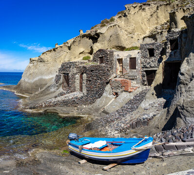 Sizilien, Liparische Inseln: Der kleine Strand mit Boot und Felsen mit türkis-blauem Wasser von Pollara