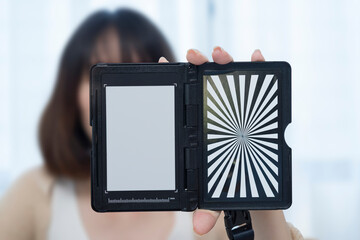 Custom white balance in the hands of a girl. The model holds a custom white balance in its hands