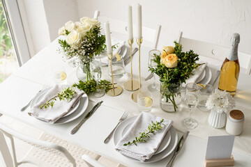 The wedding table setting, high angle view . Wedding teble decoration with white roses and boxwood