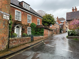 St. Swithun street view in Winchester. Street view of Winchester old town in Hampshire England Rainy day cozy brick cottages charming house. Medieval brick house facade. Georgian house