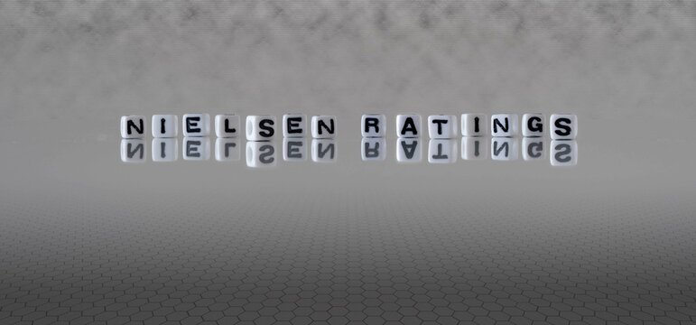 nielsen ratings word or concept represented by black and white letter cubes on a grey horizon background stretching to infinity