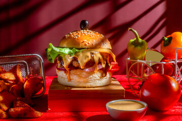 Tongue Twister Beef Naga burger with fries and tomato slice isolated on wooden board side view of...