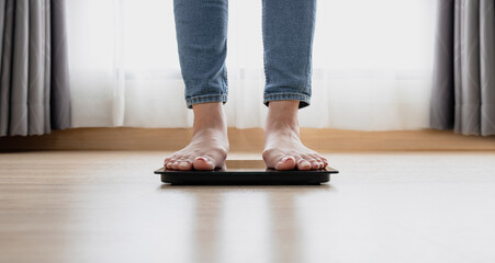 Woman's feet weighing on scales. weight loss, self care and body Concept.