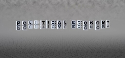 political economy word or concept represented by black and white letter cubes on a grey horizon background stretching to infinity