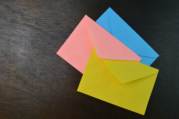 Top view of yellow, orange and blue envelopes on the table