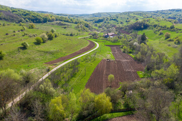 Fototapeta na wymiar Aerial view of village road passing near an agricultural field