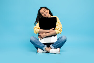 Technology Lover. Excited woman hugging laptop at studio