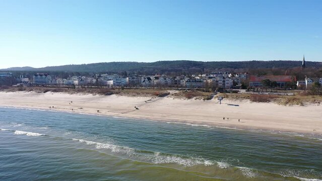 Aerial top view the coastline and Pier around city of Ahlbeck on the peninsula Usedom in Germany during a sunny day in early spring. Pier juts out into the Baltic Sea.