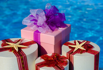 Gift boxs on the background of a blue pool.