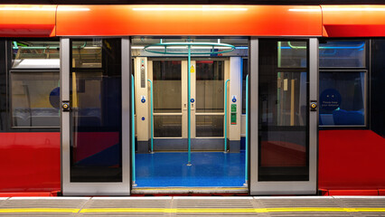 Generic underground train in London. Empty carriage with open doors standing at the platform. - obrazy, fototapety, plakaty