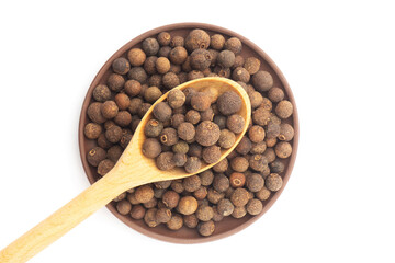 Spice Allspice in wooden bowl and clay plate on white background. Flat lay. Brown color. Indian cuisine concept