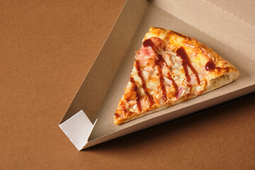 close-up of a slice of pizza in a cardboard box for serving a dish or for delivery, packaging for...