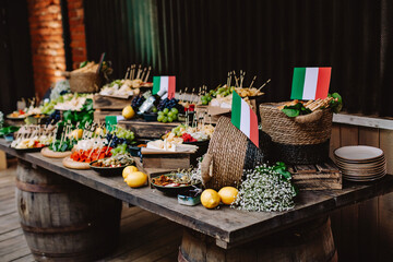 Italian cheese table decor for wedding or birthday. Flag of Italy, cheese, olives, lemons, grapes and ham.