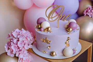 Beautiful pink cake for a girl's birthday on a background of pink balls