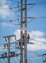 Electricians is repairing high voltage wires on electric power pole