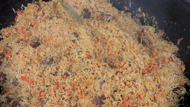 Close-up view on big cauldron with traditional uzbek food - pilaf