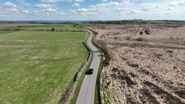 Stock footage of Black BMW X6 on rural peak district uk road. Shot with Mavic 3 Cine drone.
