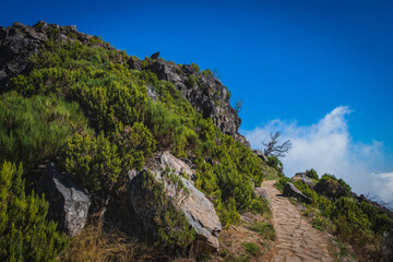 Beautiful panorama view of the footpath trail in the mountains of Madeira at Pico do Areeiro, or Arieiro while hiking to Pico Ruivo on a cloudy autumn day. October 2021