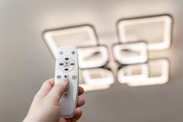 Remote control that controls the light. Neon chandelier on the ceiling