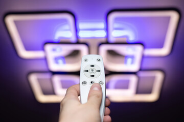 Remote control that controls the light. Neon chandelier on the ceiling