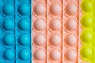 Rainbow pop it fidget toy as background, closeup