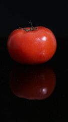 fresh red tomato vegetable on black background