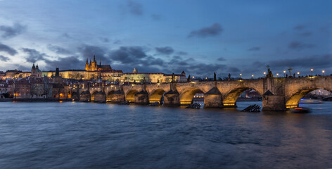 View of the Vltava River and the bridges shined with the summer sunset sun. Prague - Historic Charles bridge, Czech Republic. At night.
