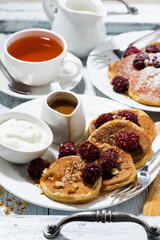 sweet corn pancakes with berries and caramel sauce for breakfast, vertical top view