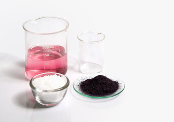 Cosmetic chemicals ingredient on white laboratory table. Potassium Permanganate Liquid, KMnO4 and Microcrystalline wax in glass container.