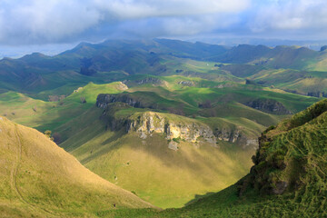 A mountain landscape seen from the top of Te Mata Peak in the Hawke's Bay region, New Zealand. The tiny figure of a hiker is just visible at the bottom