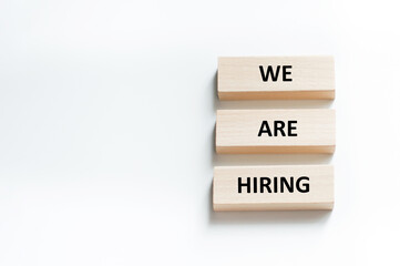 We are hiring text on wooden blocks on white background. Concept of human resources recruitment, employment or hire for a job.
