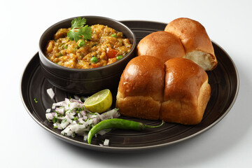 Pav Bhaji is a fast food dish from India, Thick and spicy vegetable curry, fried and served with a soft bread roll,Bun, Paav and butter. selective focus