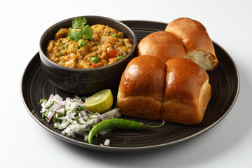 Pav Bhaji is a fast food dish from India, Thick and spicy vegetable curry, fried and served with a soft bread roll,Bun, Paav and butter. selective focus